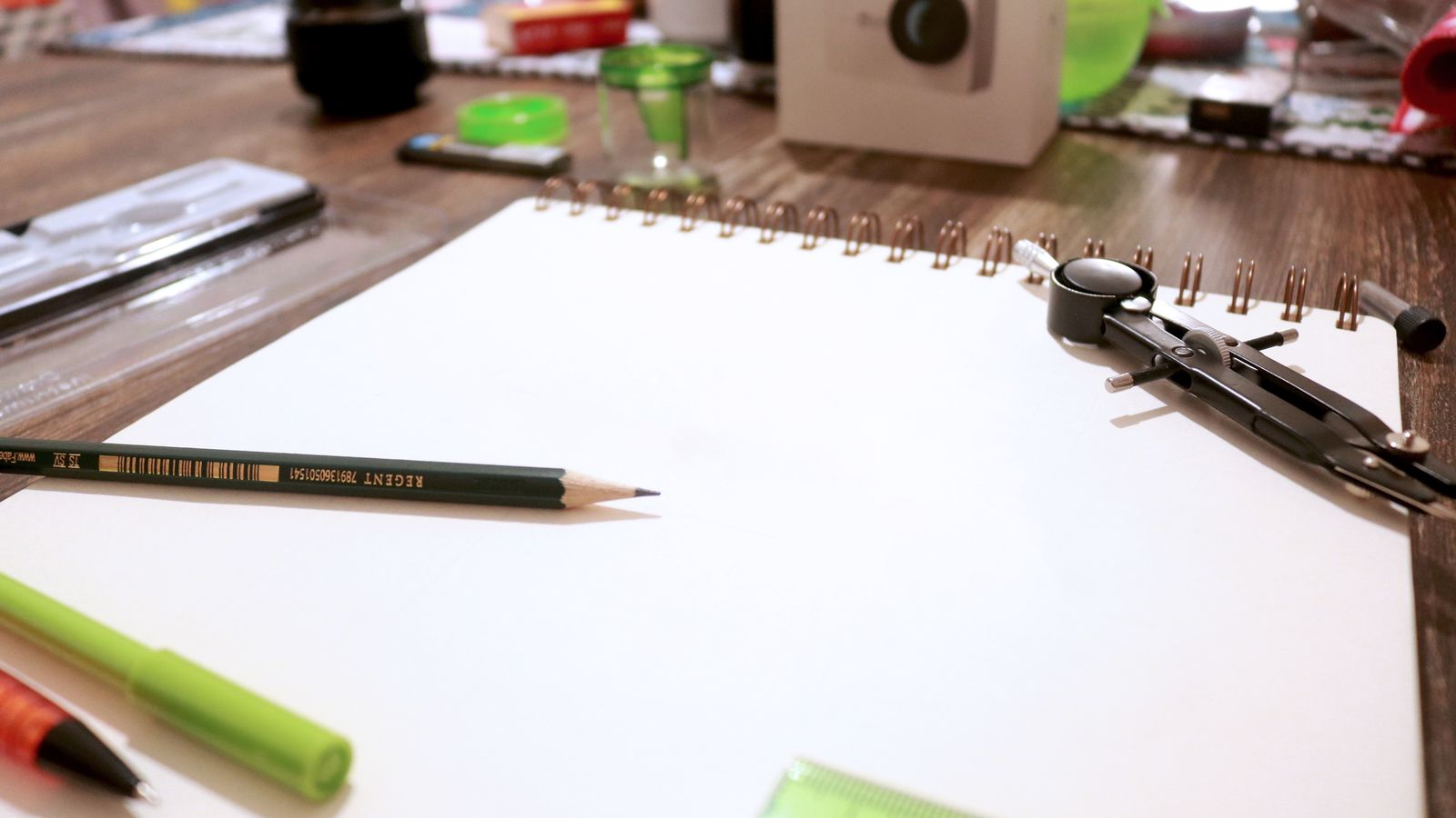 Drafting desk with layout grids, colour swatches, and a well-used notebook